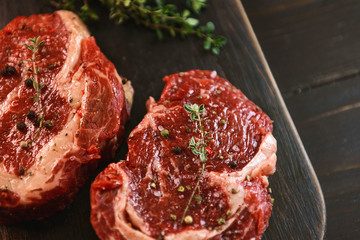 two raw marbled beef steaks in olive oil and spices ready for frying. dinner party concept
