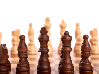 Wooden chess pieces in a duel on a chessboard. King, lady and shooter. Out of focus team of...