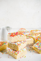 Frosted Sugar Cookie Bars, with sugar topping and colorful sugar crumbles, white marble background copy space