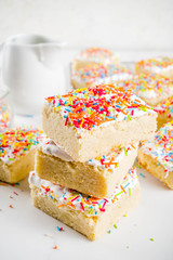 Frosted Sugar Cookie Bars, with sugar topping and colorful sugar crumbles, white marble background copy space