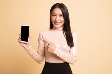 Naklejka premium Young Asian woman point to mobile phone.
