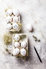 Easter holiday concept with cute handmade eggs.Funny decoration in a festive  background.Eggs with funny faces in the package.Spring mood.Copy space for Text