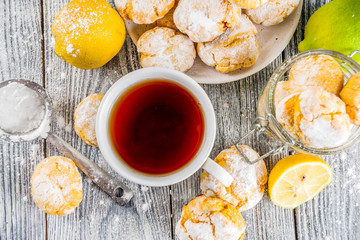 Lemon Crinkle Cookies, homemade sweet and sour baking with tea cup, white wooden background copy space