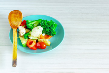 Fresh vegetables in blue plate on white background. Healthy food.