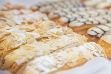 Cafe table with cups of coffee, eclairs and cake