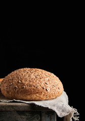 baked round rye bread lies on a gray linen napkin