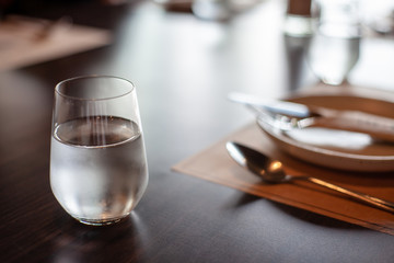 A glass of cold mineral water on the dining table in the restaurant .