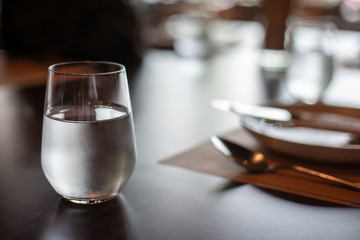 A glass of cold mineral water on the dining table in the restaurant .