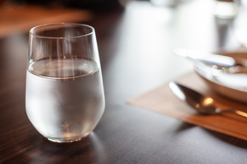 A glass of cold mineral water on the dining table in the restaurant .