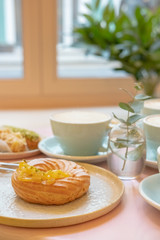 Cafe table with cups of coffee, eclairs and cake