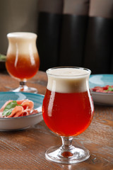 Close up view on cold amber beer in a glass with snack at bar on table. Bar image cocnept with copy space for logo or brand. Refreshing alcoholic drinks. Tasty restaurant snacks