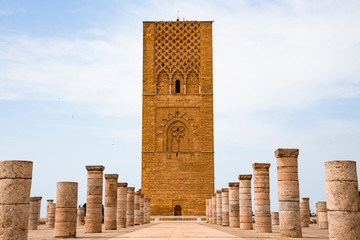 Tour Hassan tower in the square with stone columns. Made of red sandstone, important historical and tourist complex in Rabat, Morocco - obrazy, fototapety, plakaty