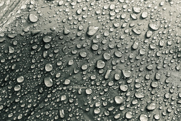 Water drops on the fabric. Rain water droplets on grey fiber waterproof fabric. Grey background.