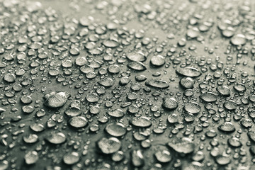 Water drops on the fabric. Rain water droplets on grey fiber waterproof fabric. Grey background.