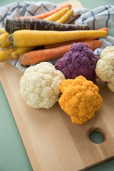 Bunte Urkarotten, Möhren und Blumenkohl Gemüse in Lila, Orange und Gelb mit Geschirrtuch und...