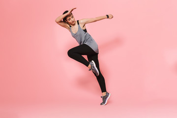Fototapeta na wymiar Amazing beautiful young pretty fitness woman running make sport exercises isolated over pink wall background.