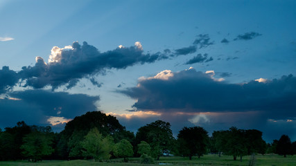 Fototapeta na wymiar Storm clouds over green fields at dawn