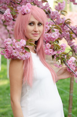 Fototapeta premium Spring woman in cherry flower bloom concept with girl sakura. Pregnant woman