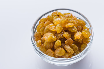 golden raisins on a white acrylic background