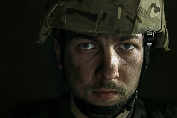 Endless war inside me. Close up portrait of young male soldier. Man in military uniform on the war. Depressed and having problems with mental health and emotions, PTSD, rehabilitation.
