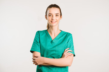 Cheerful female doctor in green uniform.