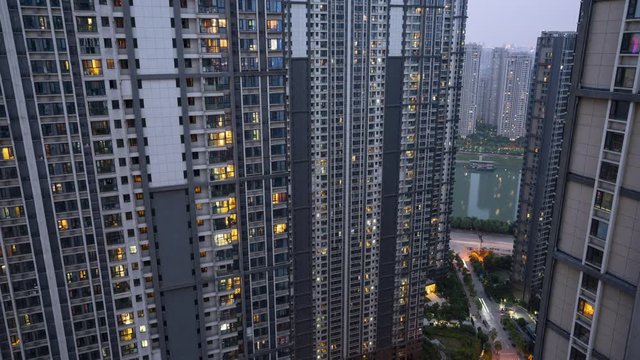 Day to night transition Timelapse of light in the windows of several multi-storey high-rise residential modern city building and street view in Wuhan China