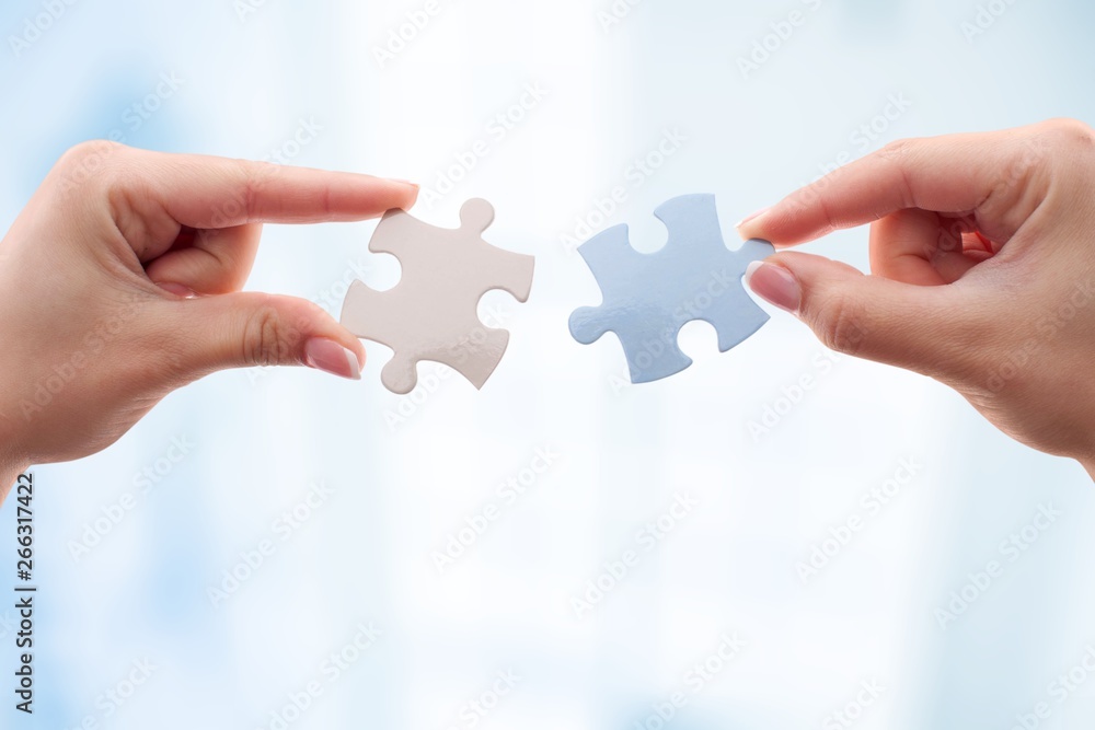 Wall mural Human hands joining puzzle parts on background