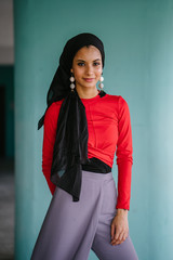 An Asian lady is set up for the photo shoot. She is extraordinarily captivating in her red office clothing.