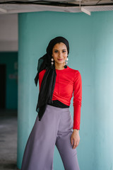 An Asian lady is set up for the photo shoot. She is extremely appealing in her red office clothing.