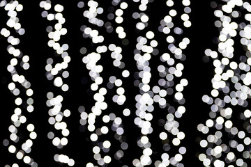 Abstract bokeh of white city lights on black background. defocused and blurred many round light