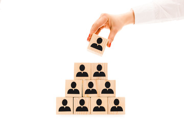 cropped view of woman picking up one wooden block with black human icon from pyramid isolated on...