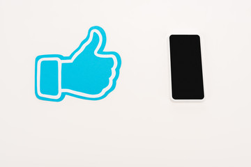 Fototapeta premium blue thumb up sign near laptop with blank screen isolated on white