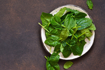 Fresh, young green spinach on a concrete background. View from above.