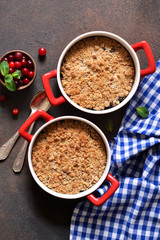 Crumble with cranberries and other berries, nuts on the kitchen table. View from above.