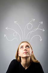 Frustrated young woman in thoughts. Arrows over her head.