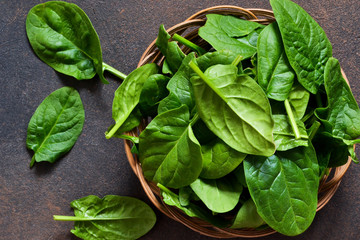 Fresh, young green spinach on a concrete background. View from above.