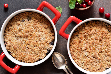Crumble with cranberries and other berries, nuts on the kitchen table. View from above.