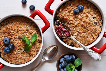 Crumble with blueberries on a white kitchen table. View from above.