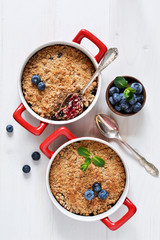 Crumble with blueberries on a white kitchen table. View from above.