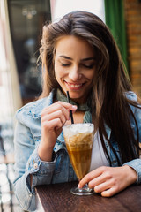 Portrait of smiling beautiful woman drinking cold coffee. Beautiful woman at the coffee shop.