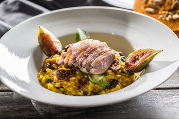 Pumpkin risotto roasted duck breast figs zucchini and min leaves. italian or mediterranean cuisine