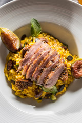 Pumpkin risotto roasted duck breast figs zucchini and min leaves. italian or mediterranean cuisine
