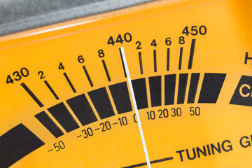 Macro close up detail of calibration meter on old guitar tuner.