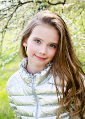 Portrait of adorable smiling little girl child outdoors in spring day