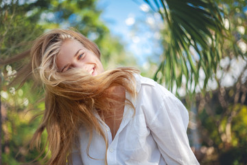 Fototapeta premium young happy blonde beautiful girl on tropical sea background, smiling happy girl outdoor portrait