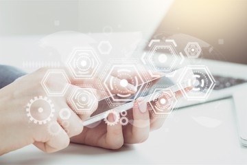 Hands typing on phone of modern laptop