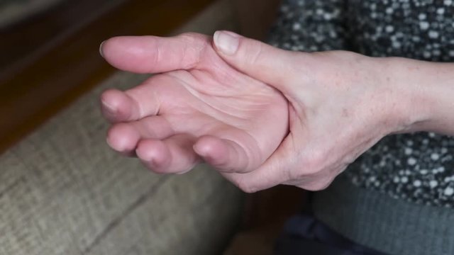 A woman strokes the painful joint of the hands.