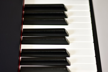 Keys of a digital piano, soft focusing, creative mood of a person improvisation and creativity. Midi piano keyboard for playing digital music and making remixes.