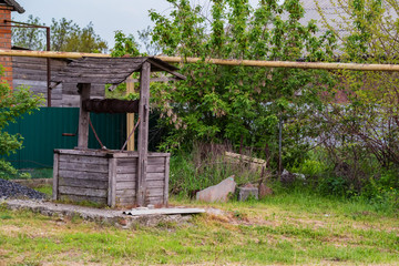 Fototapeta na wymiar Old wooden well in back yard in the countryside