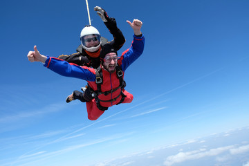 Tandem skydiving. Two happy men are in the sky.